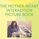 Mother reading to infant in a cozy setting.