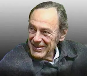 Portrait of an elderly man with a gentle smile and gray hair.