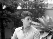 Resolving Yesterday Young man sitting outdoors near a large succulent plant.