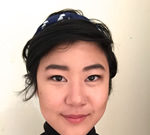 The Man Who Couldn’t Stop: Portrait of a woman with short black hair and a black turtleneck.