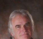 On the Significance of “Bodymind” Visioning for the Profession and for the Planet Portrait of a mature man with gray hair and a calm expression.