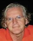 The Handbook of Body Psychotherapy and Somatic Psychology: A Day LongCelebration Smiling man with glasses and gray hair wearing an orange shirt.