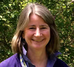 Addressing Sexuality in Bioenergetic Therapy A woman smiling outdoors with greenery in the background.