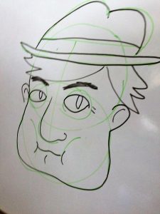 Cartoon face with hat drawn on board.