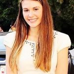 Young woman smiling in outdoor setting.