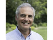 Alex Diaz, PhD Smiling elderly man in a blue striped shirt outdoors.