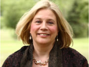 Dr. Diane Poole Heller Smiling woman with blonde hair outdoors in a natural setting.