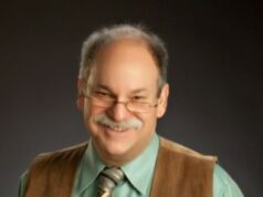 Over Coming the Obstacles to Self-Compassion Smiling older man with glasses and a mustache in a brown vest.